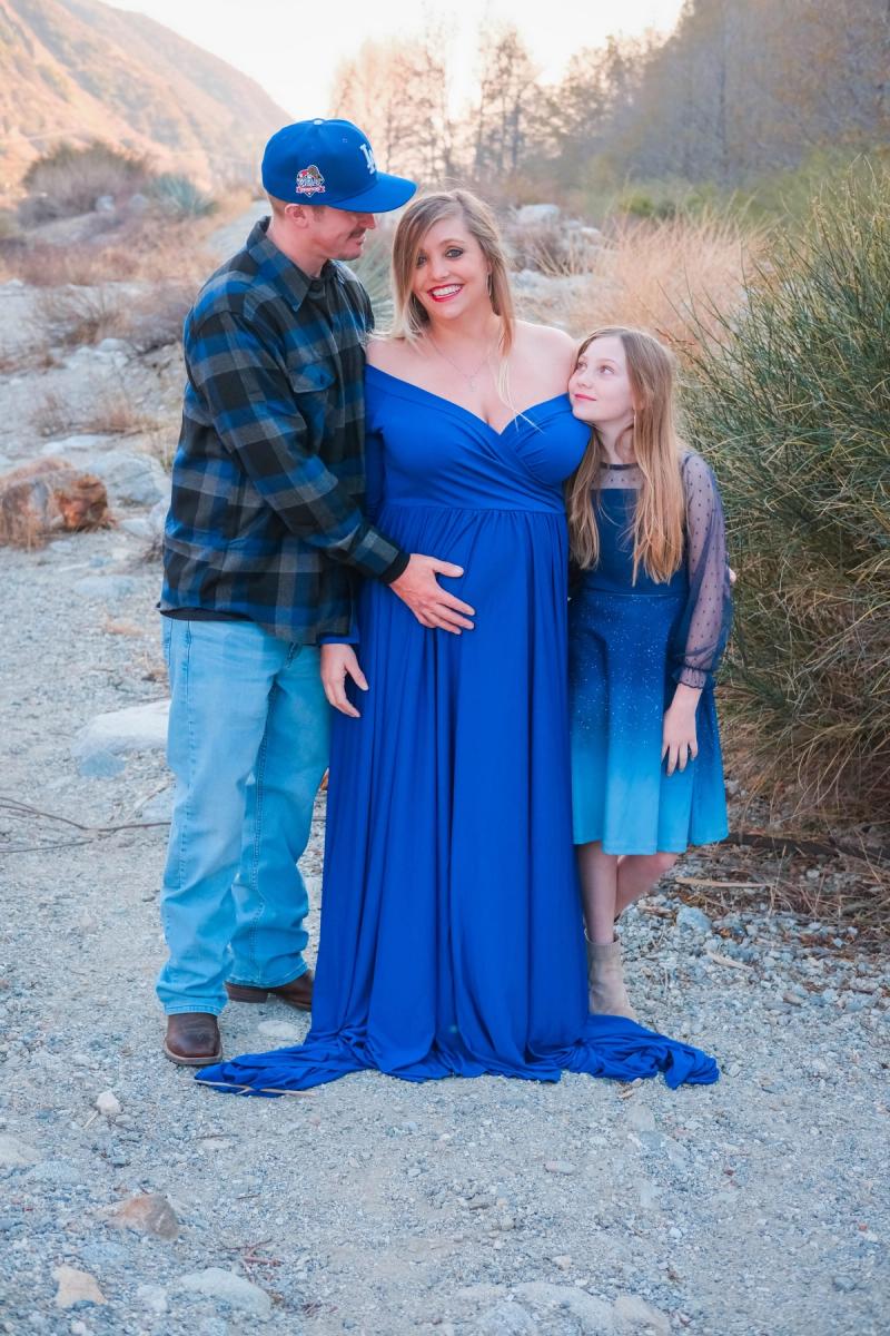 Family of three standing together in the foothills