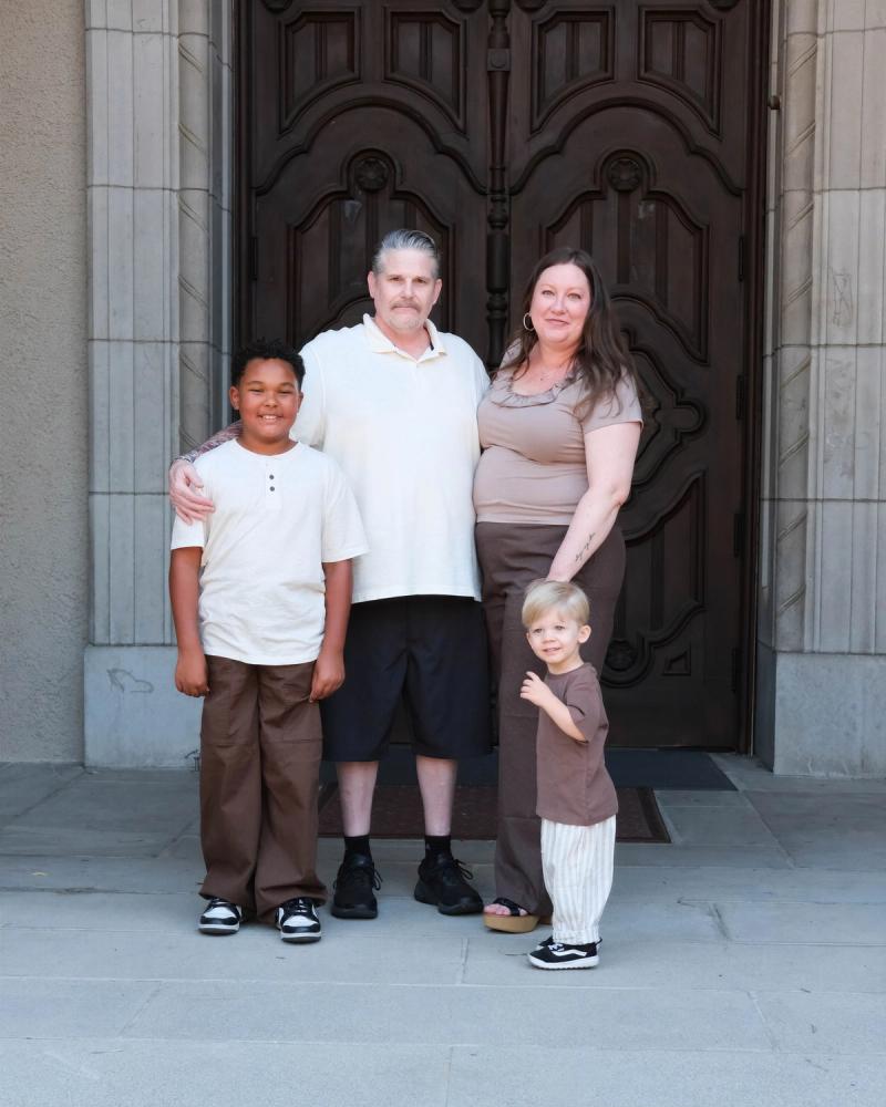 Grandparents with their two grandsons standing in front of carved wooden church doors