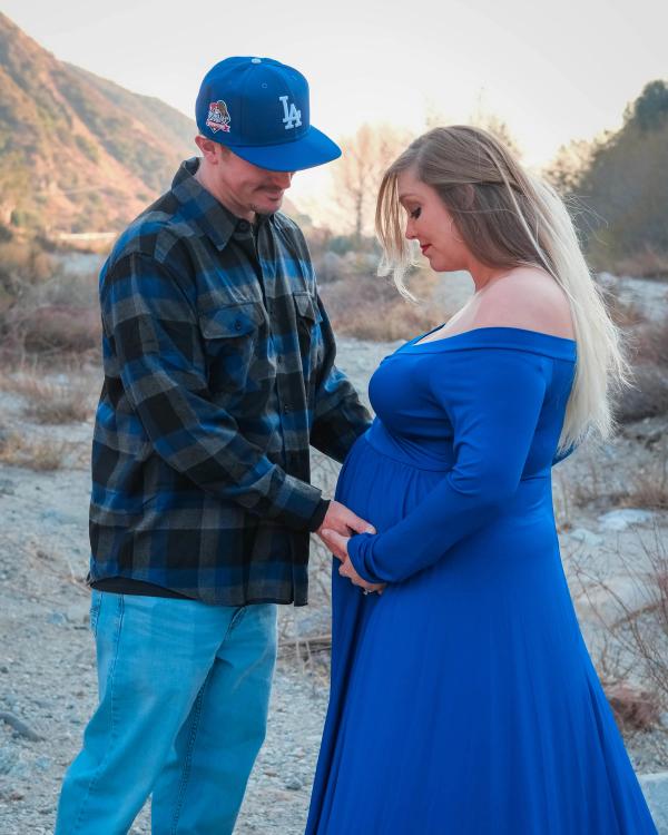 Parents-to-be smiling down at the bump together