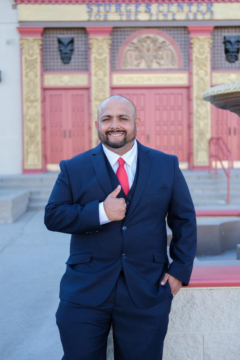 Candidate with hand on heart in front of a historic theater