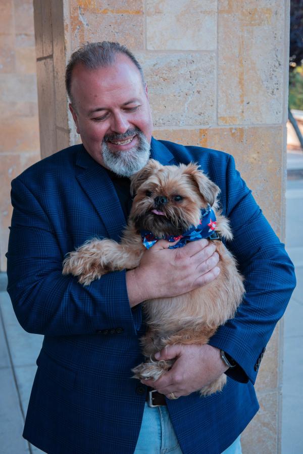Candidate smiling while holding his small dog