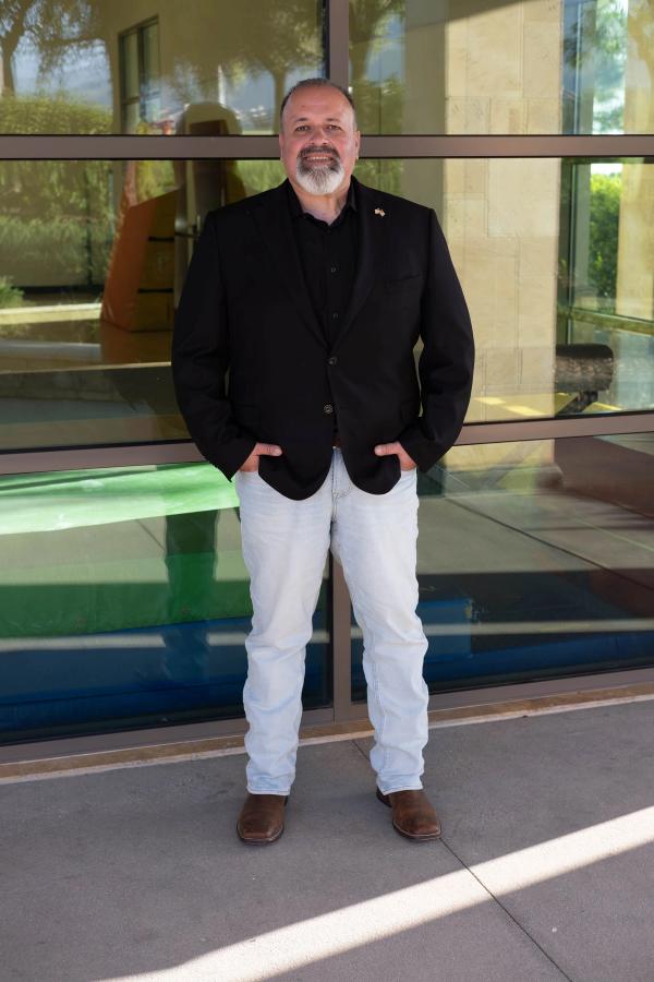 Candidate standing in front of glass doors with hands in pockets
