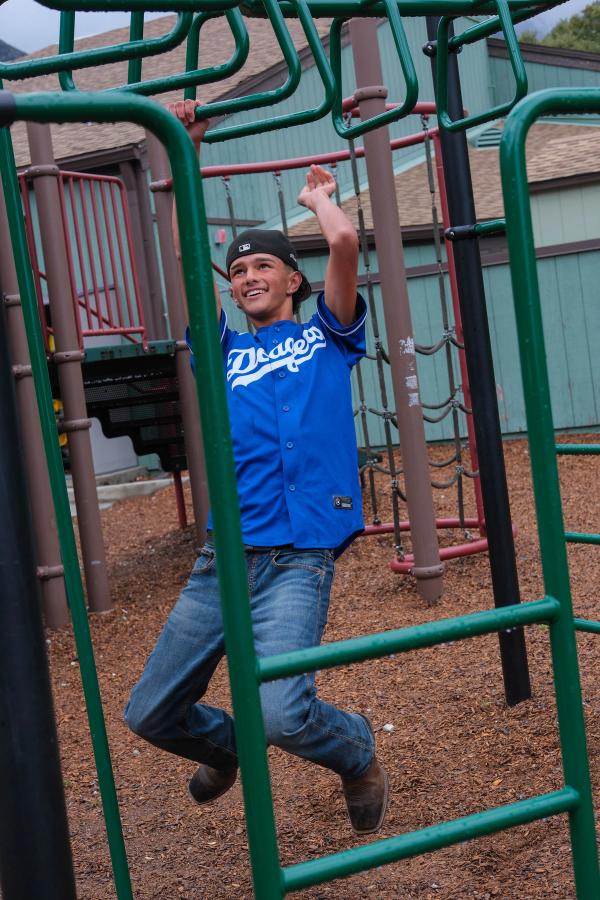 Teen in a Dodgers jersey climbing the play structure
