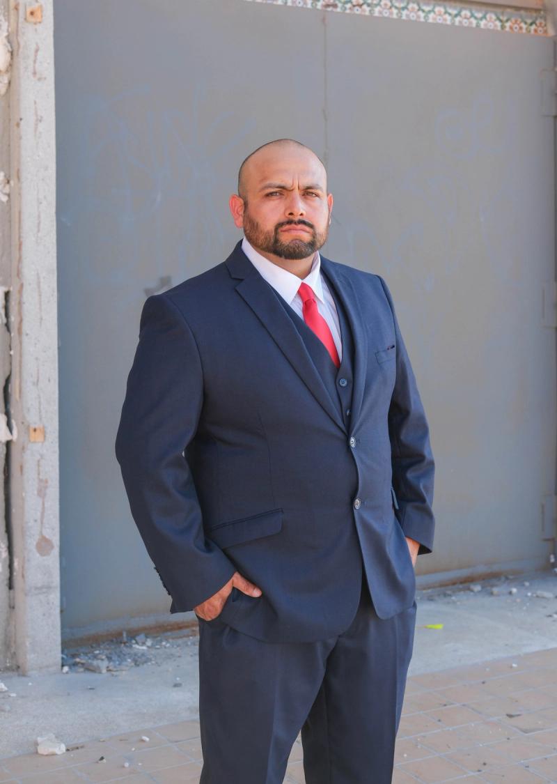 Candidate standing in front of a weathered downtown wall