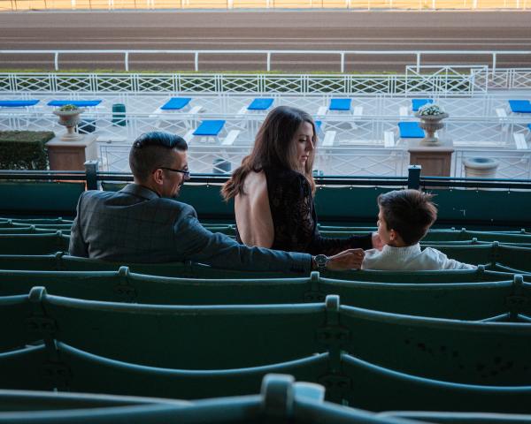 Family sitting together in the teal grandstand seats overlooking the track