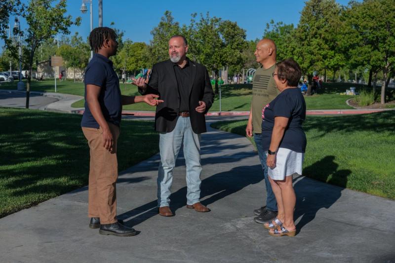 Candidate talking with community members in a park