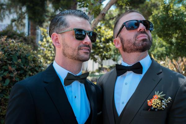 Grooms in sunglasses posing together after the ceremony