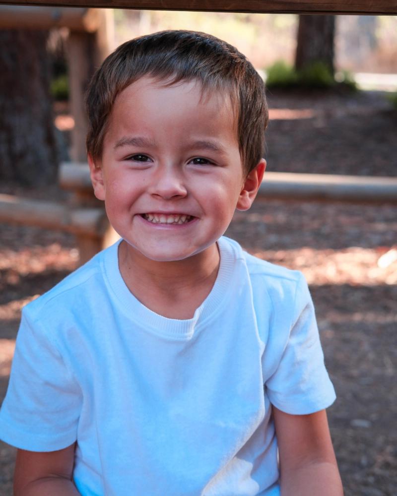 Close portrait of a smiling little boy in a white T-shirt