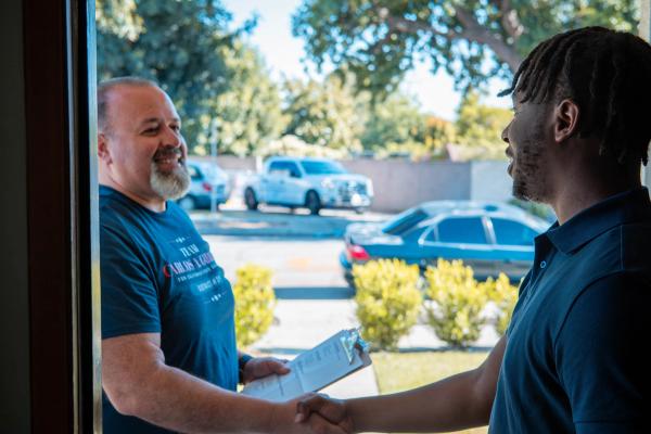 Candidate shaking hands with a voter at the front door