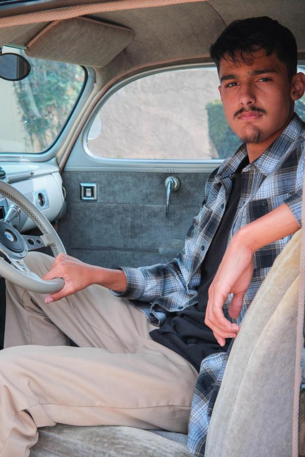 Senior sitting behind the wheel of a classic car