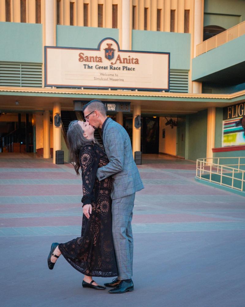 Couple kissing in front of the Santa Anita Park entrance