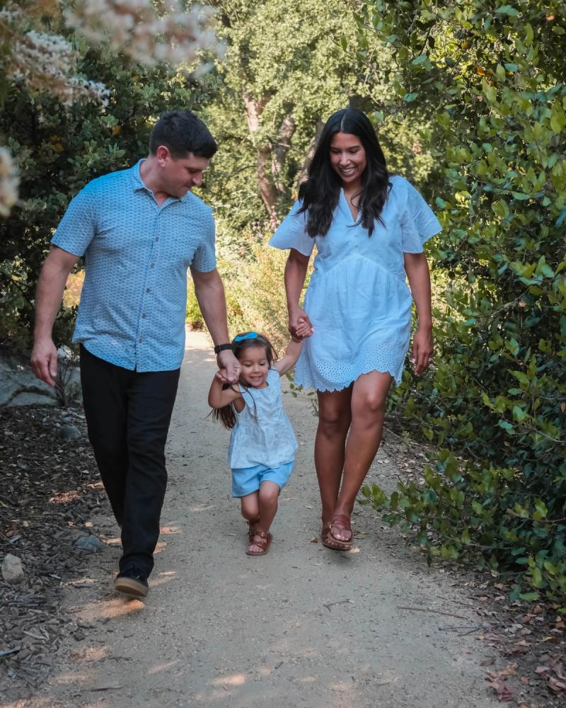 Family walking hand in hand down a wooded path