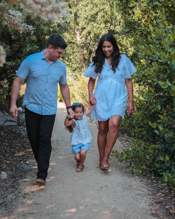 Family walking hand in hand down a wooded path