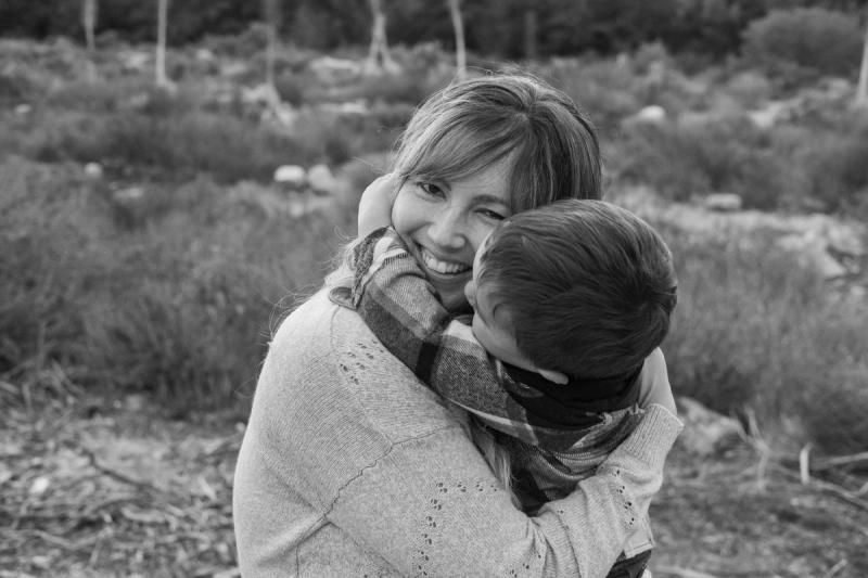 Black and white photo of a mom hugging her toddler son close
