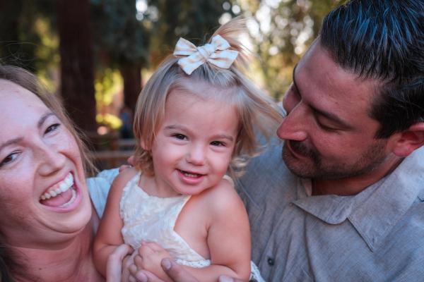 Parents laughing with their toddler girl between them
