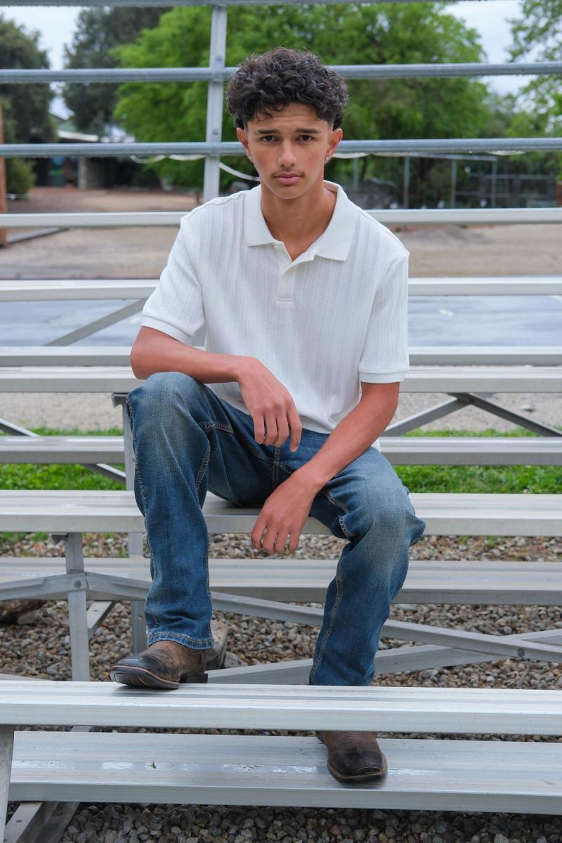 Teen sitting on the bleachers by the school field