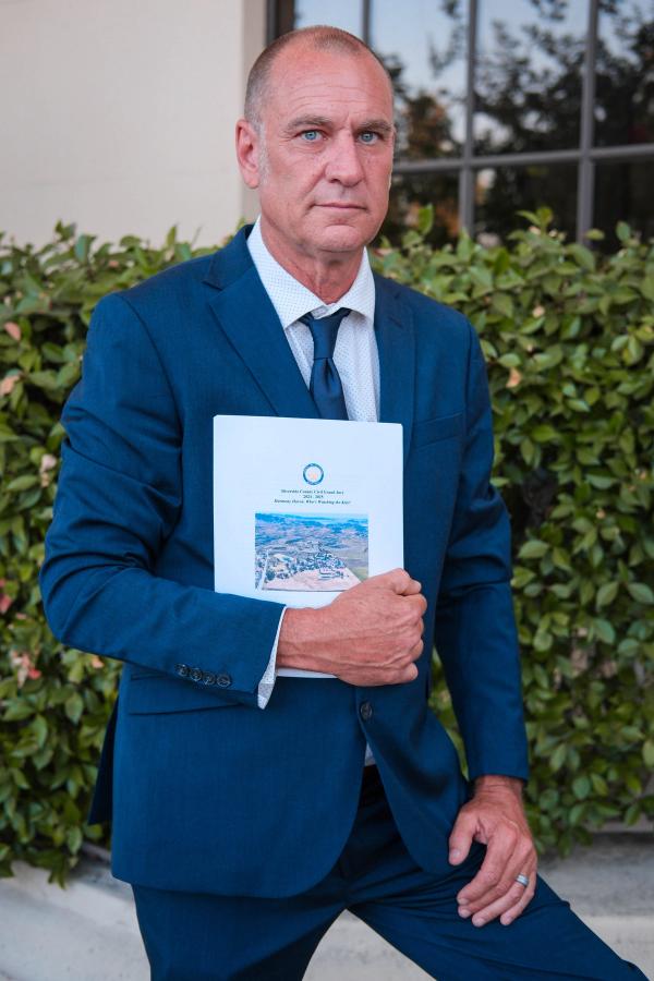 Candidate holding a city report outside a civic building