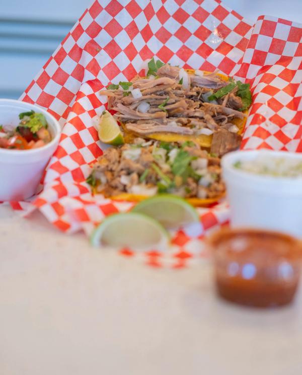 Plate of tacos with salsa, lime and sides on the counter