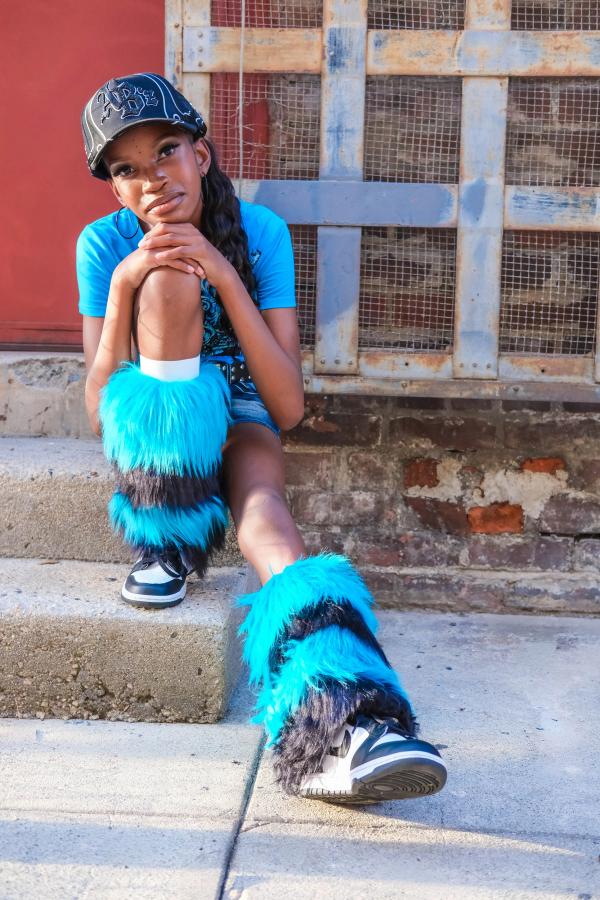 Girl sitting on steps in her fuzzy blue boots in front of a red door