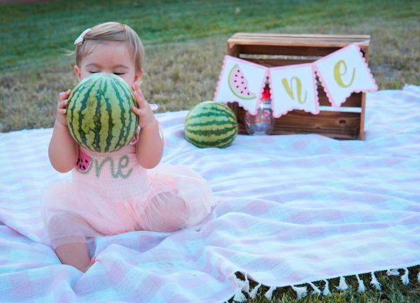 Little girl hugging a watermelon almost as big as she is
