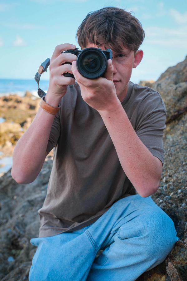 Teen photographer aiming his camera back at the viewer