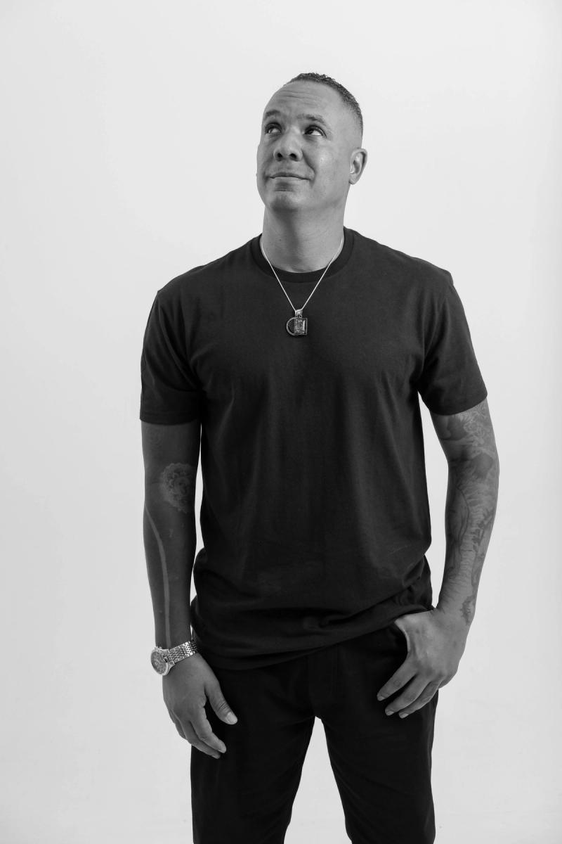Man in a black T-shirt looking up thoughtfully