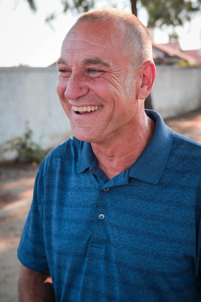 Candidate in a blue polo laughing outdoors