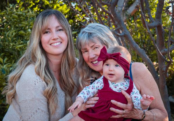 Three generations gathered around the newest baby in red