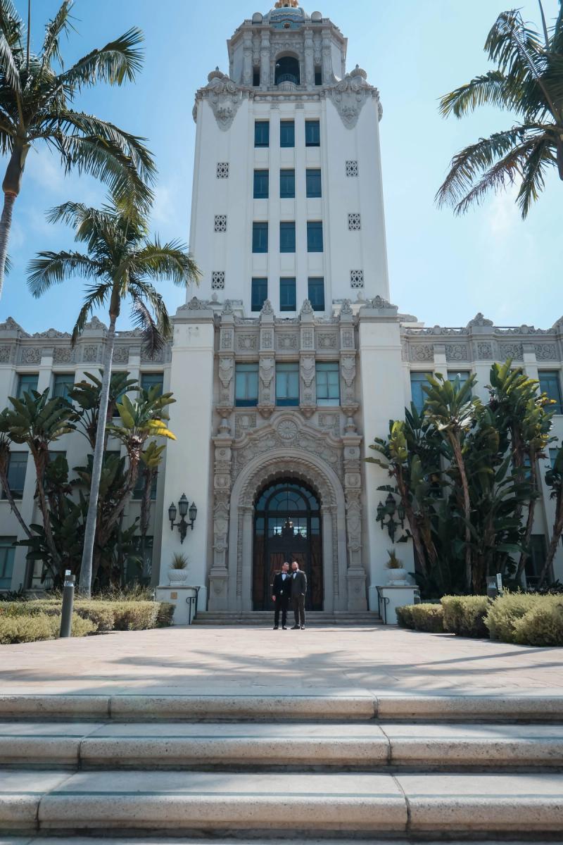 Historic white city hall tower framed by palm trees