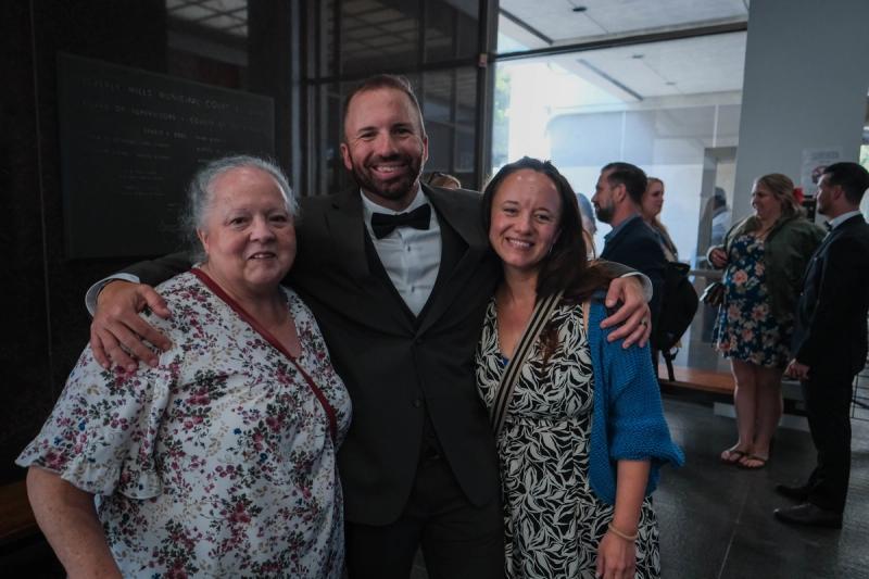 Groom hugging two family members before the ceremony