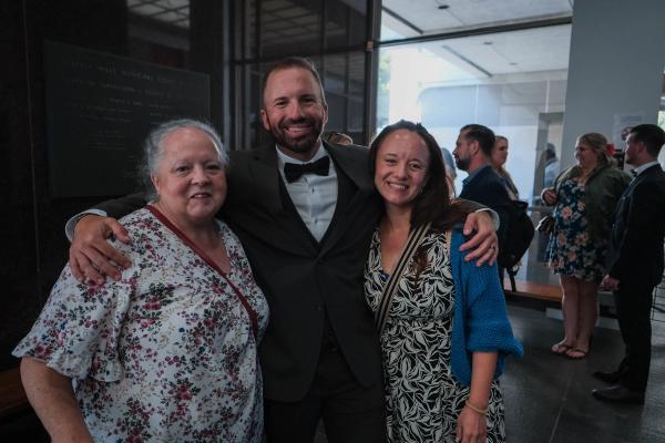 Groom hugging two family members before the ceremony