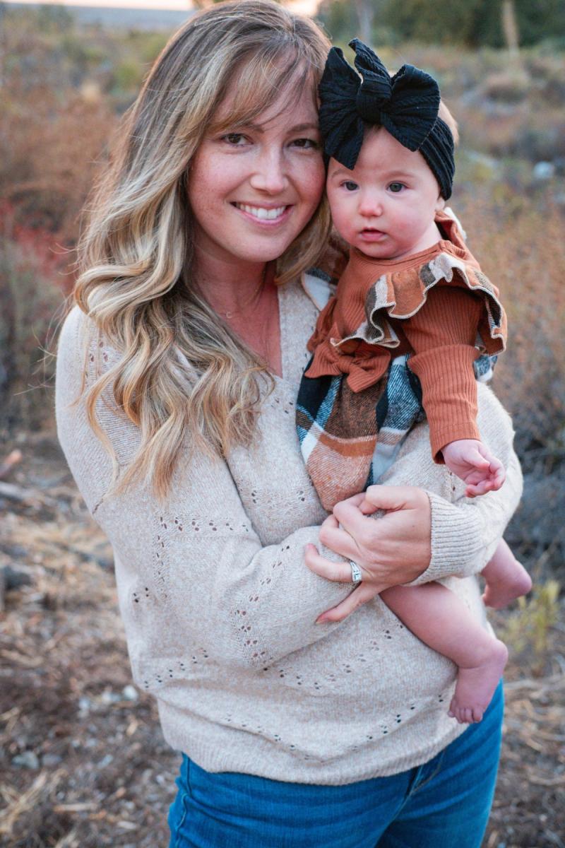 Mom cradling her baby girl in a big hair bow