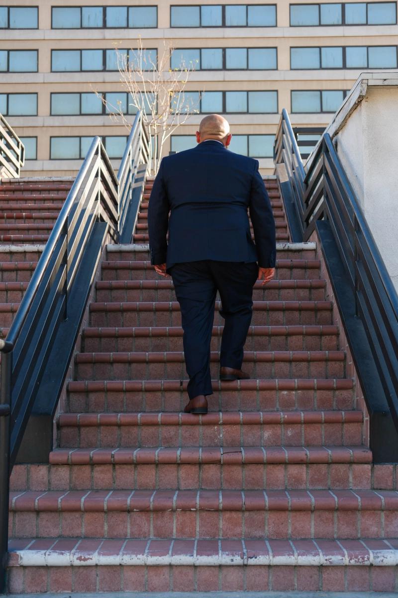 Candidate walking up a long outdoor staircase downtown