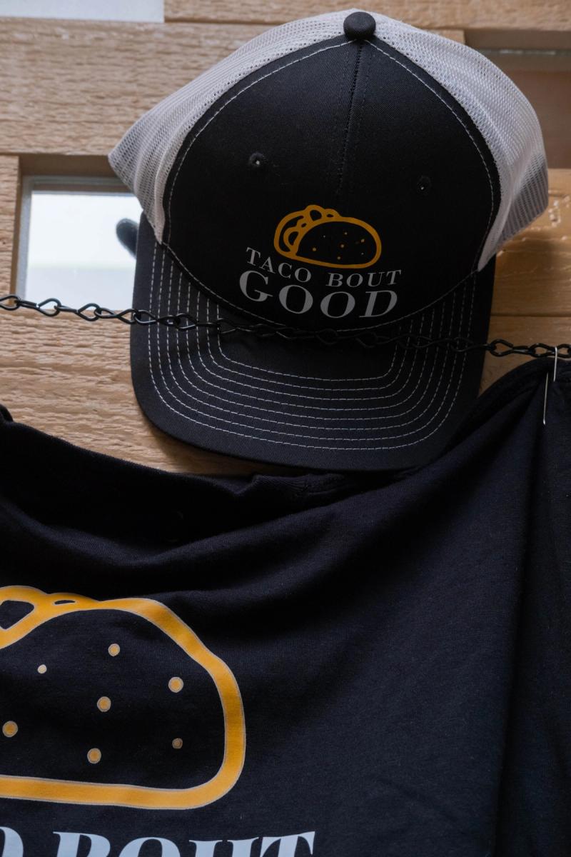 Taco Bout Good trucker hat hanging on the merch wall