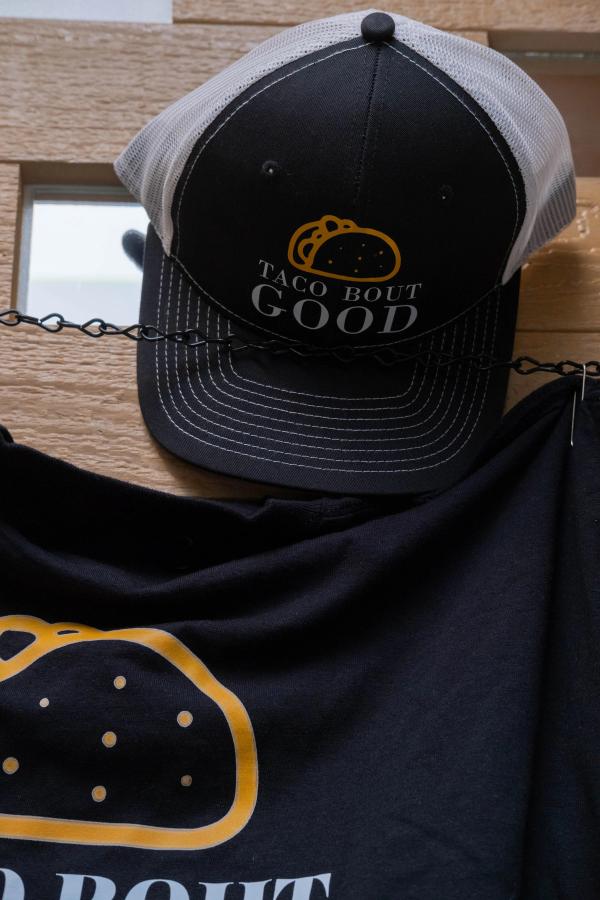 Taco Bout Good trucker hat hanging on the merch wall