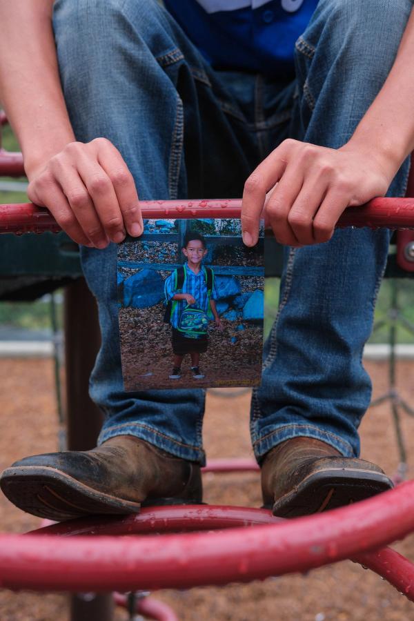 Childhood photo held between his boots on the playground