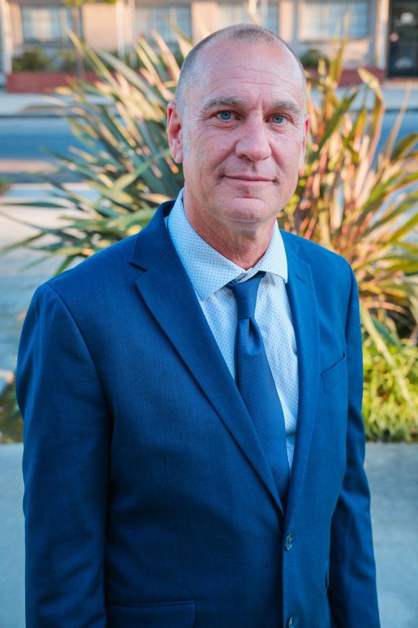 Campaign portrait of a candidate in a blue suit and tie