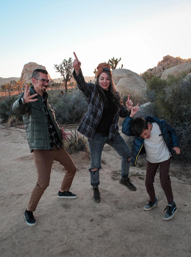 Family striking silly poses together in the desert