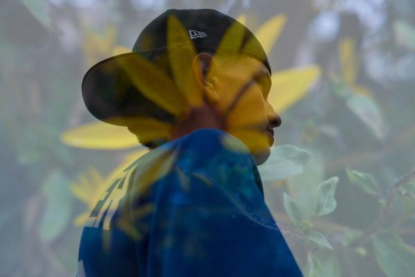 Double exposure of a teen in profile blended with a yellow flower