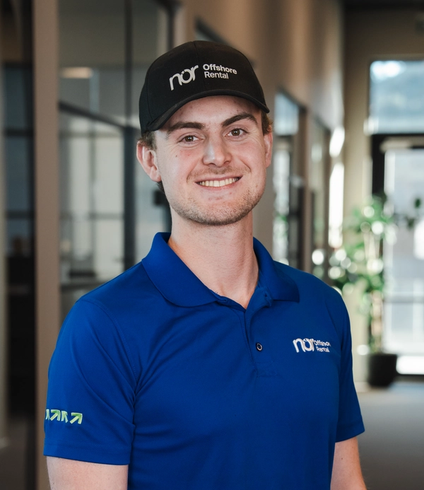 A smiling young man in a blue polo shirt and a black baseball cap with "nor Offshore Rental" logos.