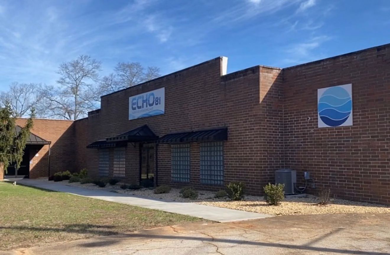 A brick building with an "ECHO BI" sign and a blue wave logo.