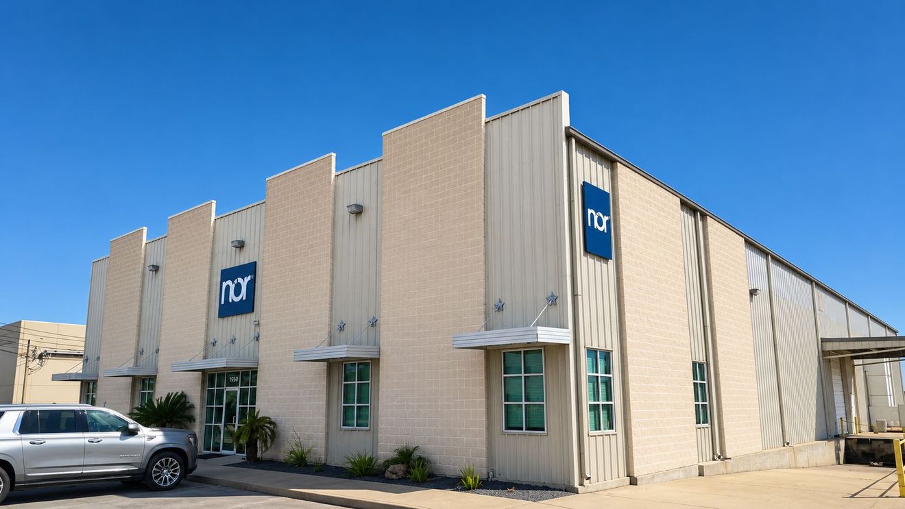 Modern commercial building with "nor" logos, a silver SUV, and a loading dock.