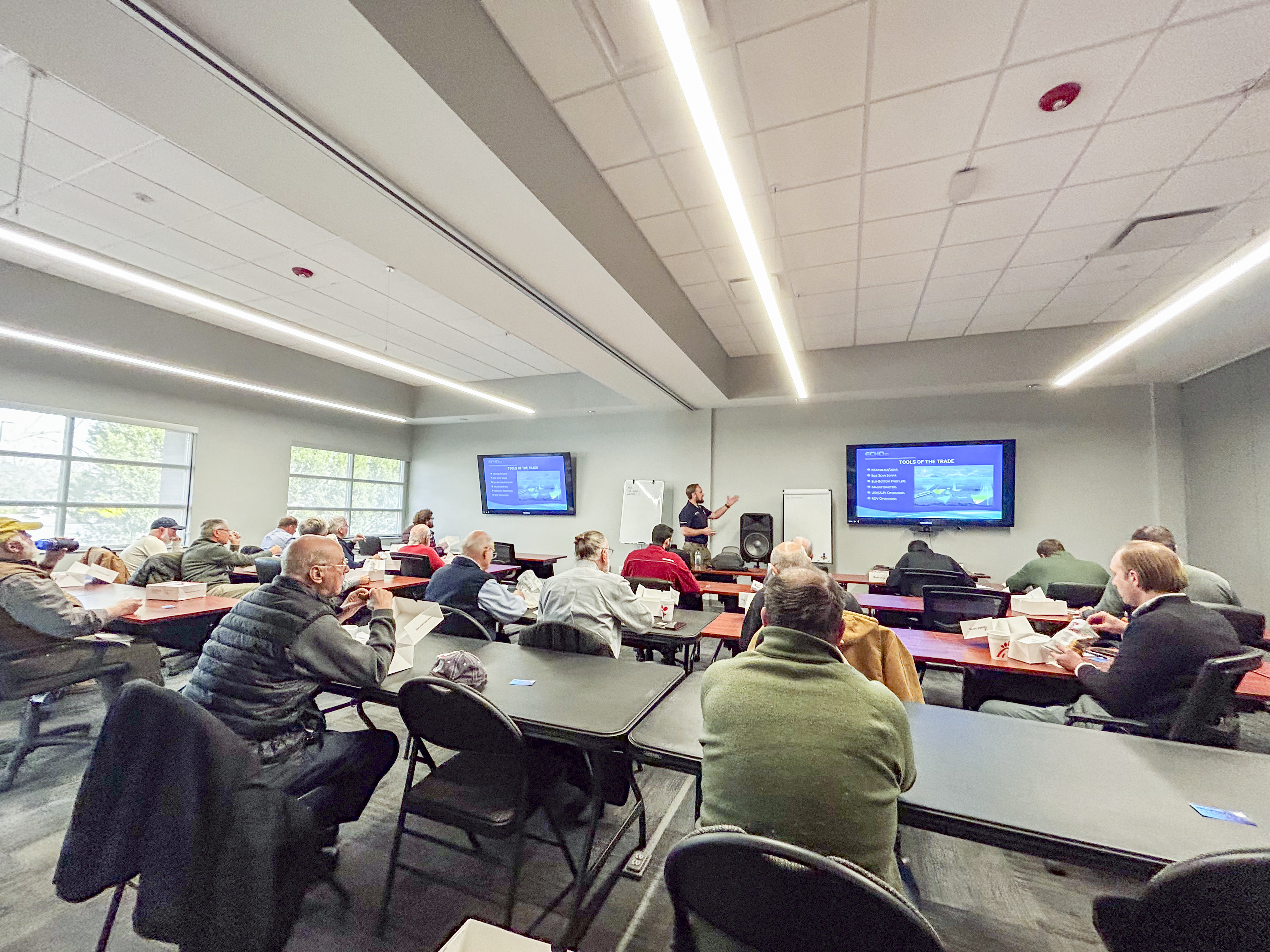 A group of adults attends a presentation in a conference room.