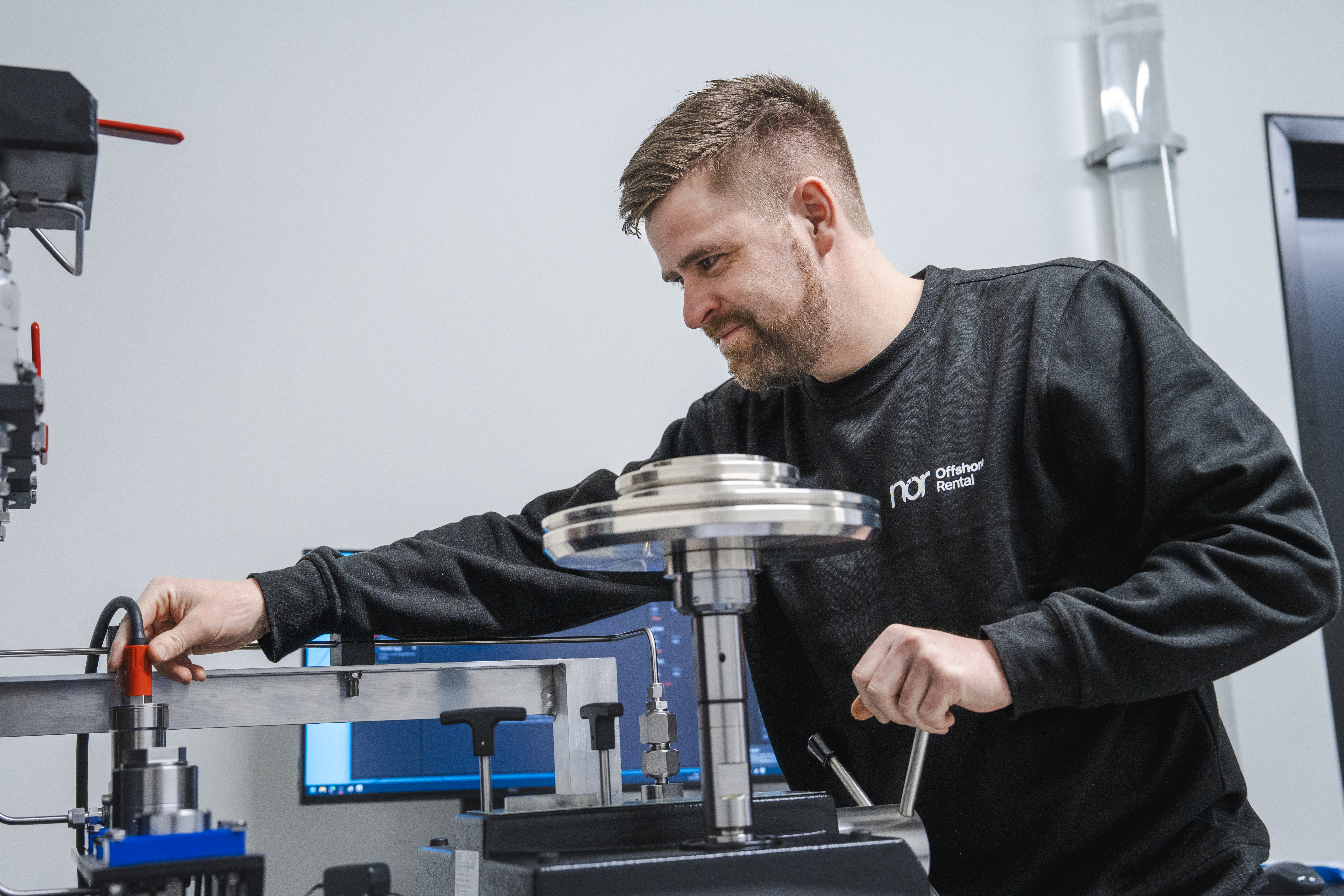A man operates industrial testing equipment.