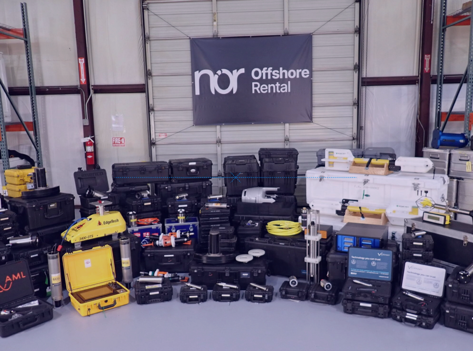 A wide array of black, yellow, and white offshore rental equipment displayed in a warehouse beneath a "nor Offshore Rental" banner.