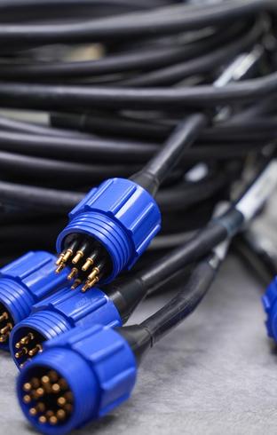 Coiled black cables with five blue multi-pin connectors showing gold pins.