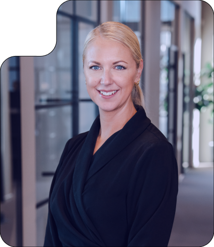 Smiling blonde woman with blue eyes in a black top.