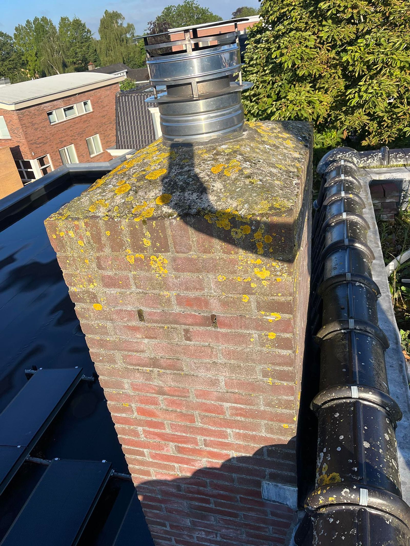 Schoorsteen met verweerd voegwerk en oud lood voor de renovatie