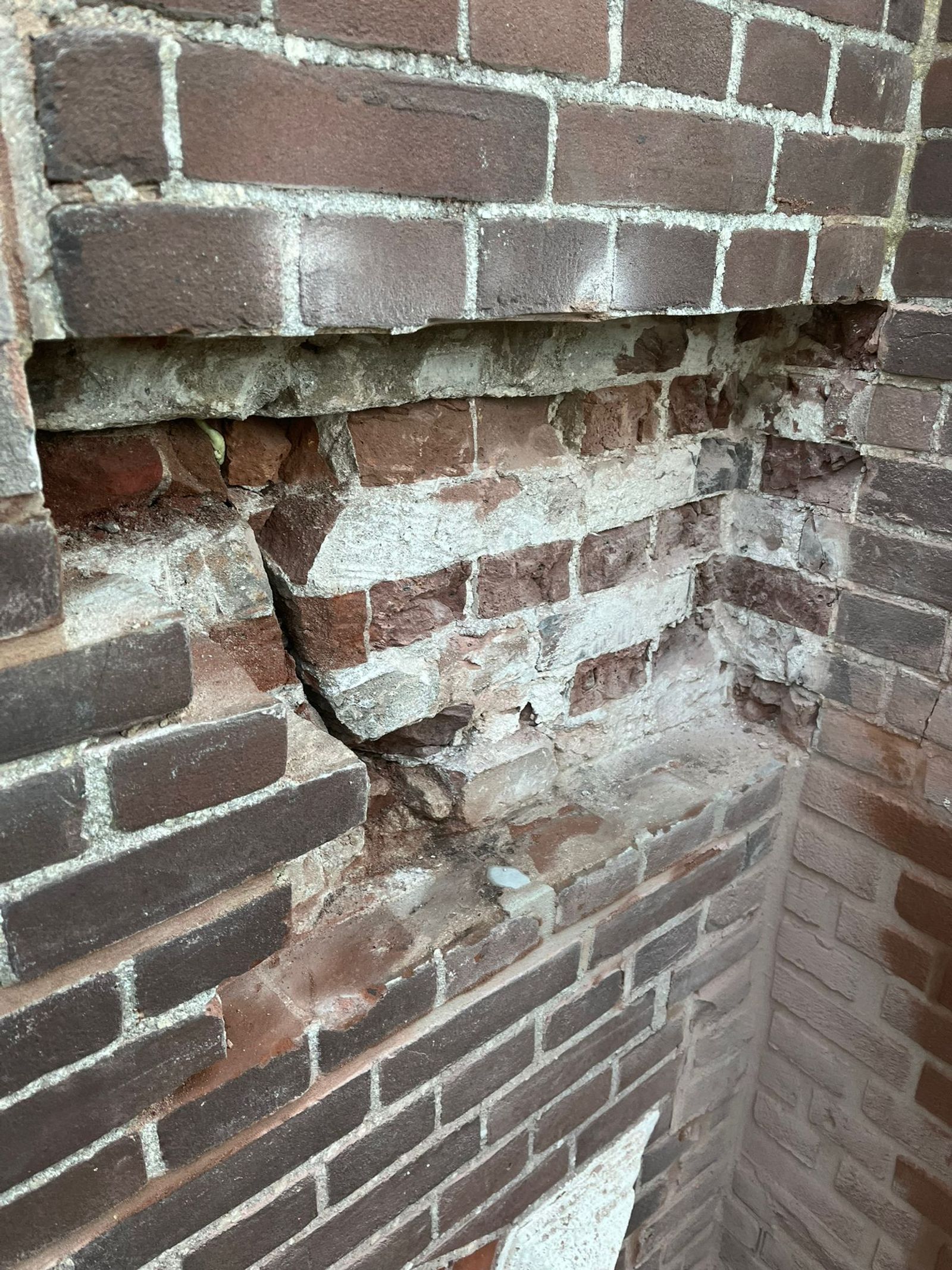Vakman herstelt beschadigd metselwerk in een bakstenen gevel