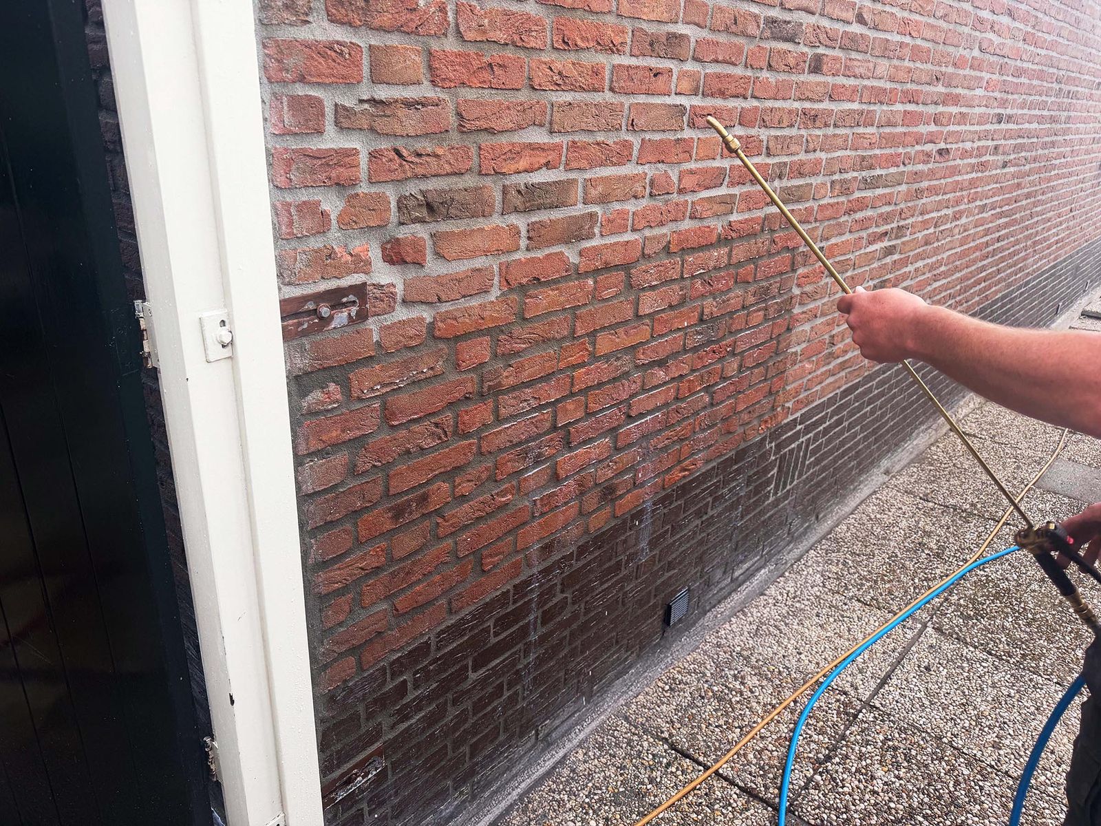 Waterdruppels parelen af op een geïmpregneerde rode bakstenen gevel